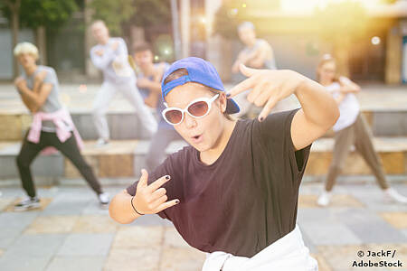 Eine junge Frau mit verdrehtem Baseballcap und einer Sonnenbrille schaut in die Kamera. Foto: JackF/AdobeStock