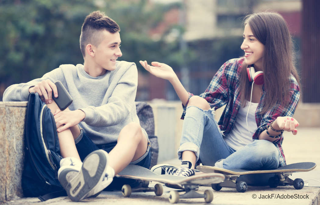 Ein Junge und ein Mädchern, die auf Skateboards sitzen. Foto: JackF/AdobeStock. 