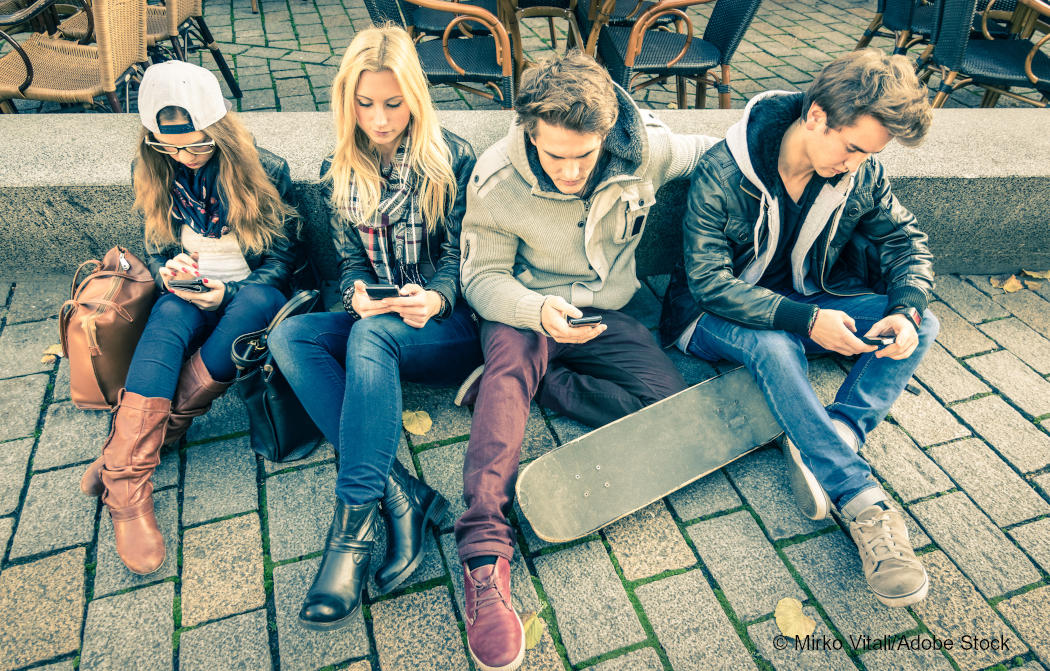 Vier Jugendliche mit Smartphones in der Hand. Foto: Mirko Vitali/Adobe Stock.